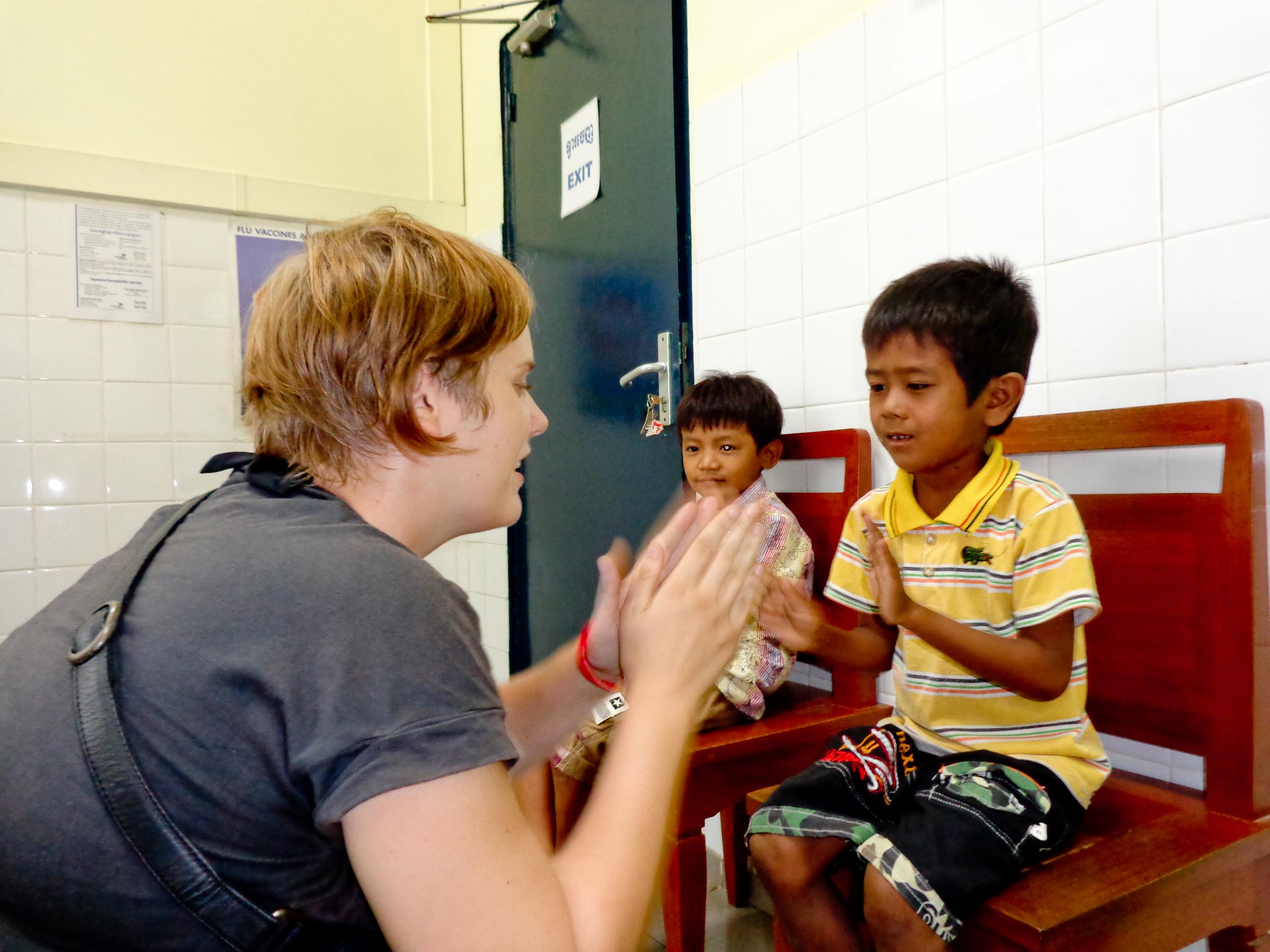 A female intern with Projects Abroad clapping with a child during her occupational therapy internship in Cambodia. A female intern from projects Abroad can be seen clapping with a child during her occupational therapy internship in Cambodia.